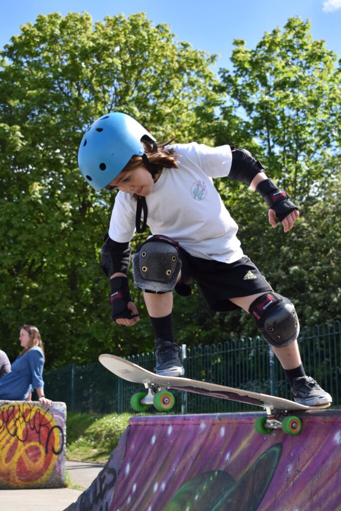 One of students is using her skateboard to drop in one of the larger ramps, during one of our lessons at Jackson's field skateboarding park Skateboarding