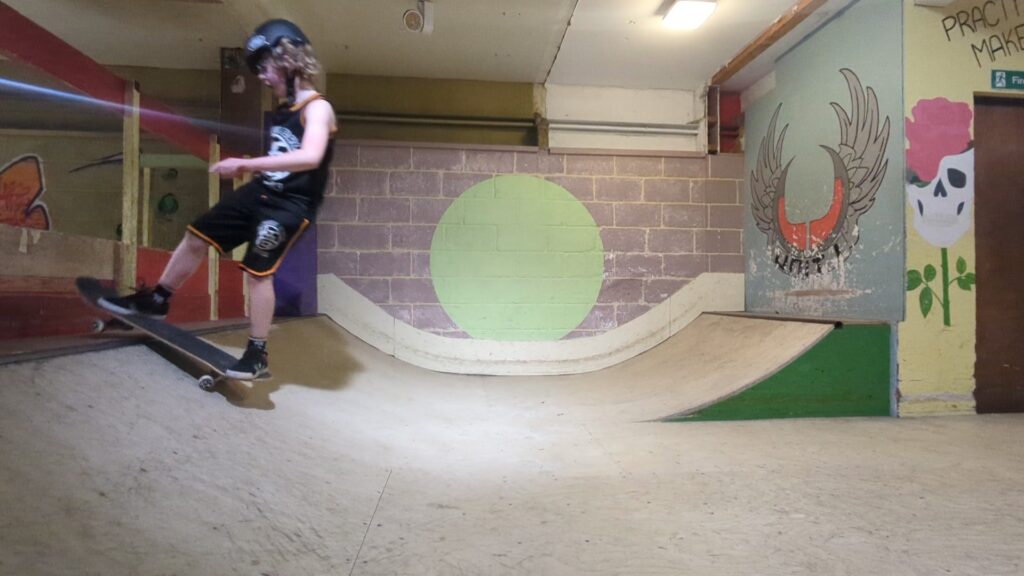 Skateboarder performing a rock to fakie trick at Unit 1 Skatepark.
