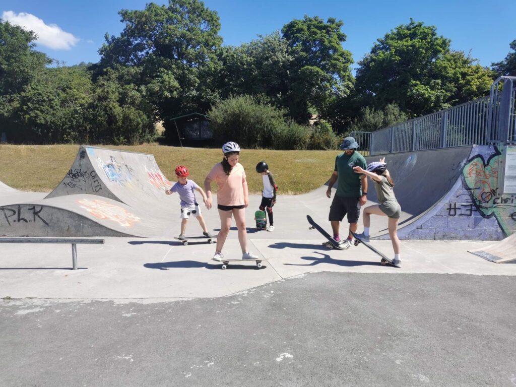 Skateboard coach Rick instructing four students at Burham Skatepark during a lesson.