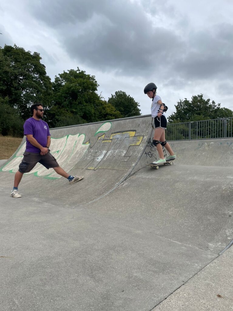 Skateboard coach Rick providing one-on-one instruction to a student during a skateboarding lesson.